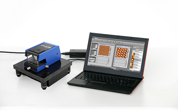 The TraxAFM on a table next to a computer